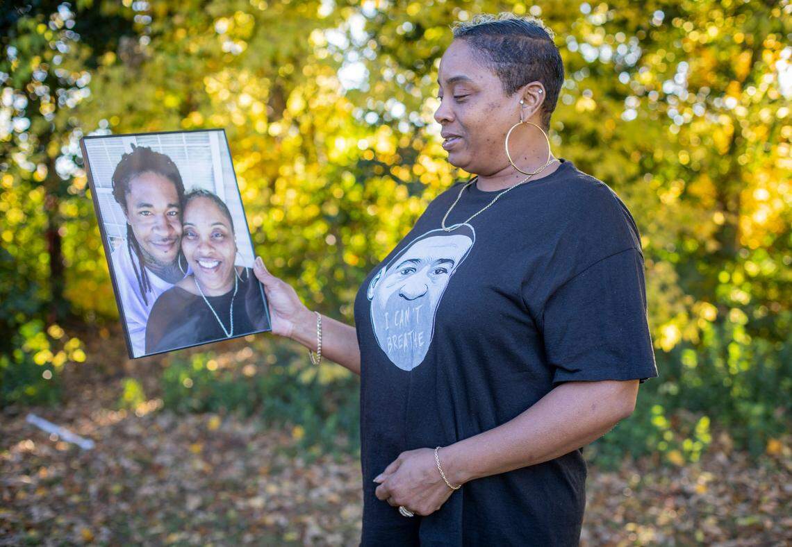Sharon Torain-Watlington holds a framed photograph of her with her husband, Courtney Watlington, at her home in Graham, N.C., on Nov. 15, 2021. Courtney died after a car chase with state troopers ended in a fiery crash in Burlington, N.C. in March of 2017. It took years for Sharon to get access to the dash camera video of the incident that lead to her husband’s death.