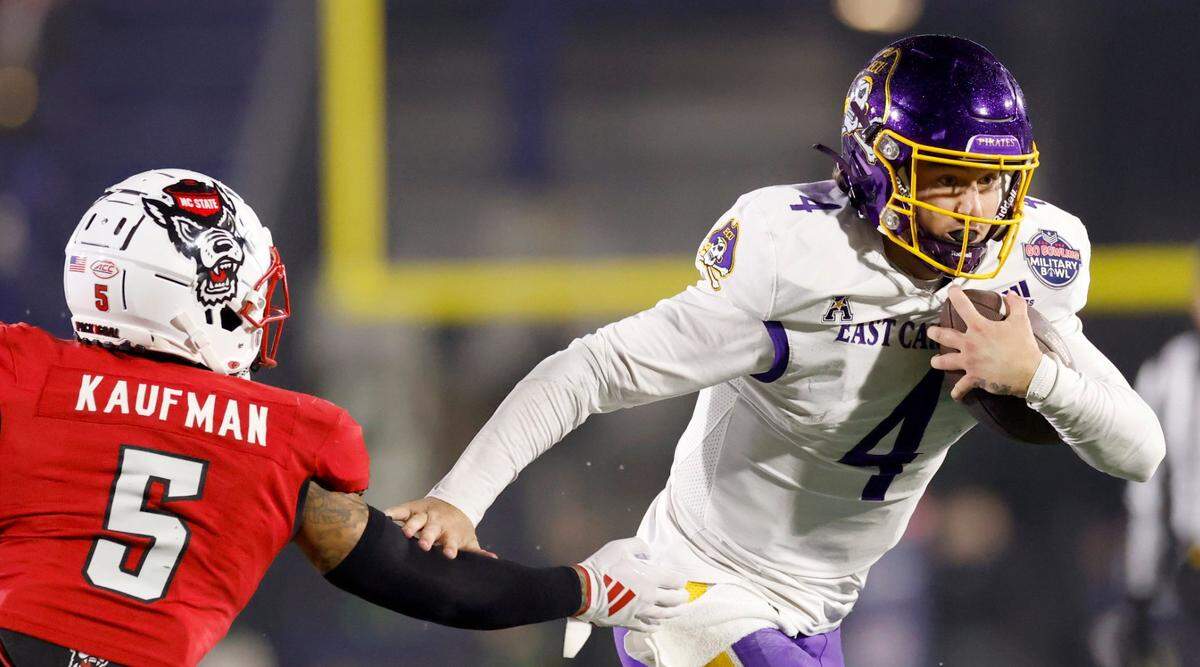 East Carolina quarterback Katin Houser (4) gets by N.C. State safety DK Kaufman (5) on a 19-yard touchdown run during the first half of N.C. State’s game against ECU in the Military Bowl at Navy-Marine Corps Memorial Stadium in Annapolis, Md., Saturday, Dec. 28, 2024.