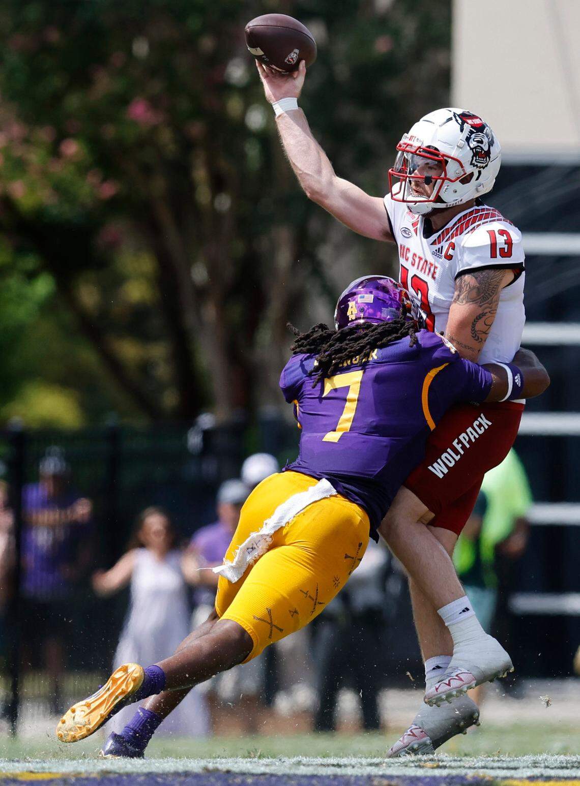 N.C. State quarterback Devin Leary (13) throws while being hit by East Carolina safety Gerard Stringer (7) during the first half of N.C. Stateís game against ECU at Dowdy-Ficklen Stadium in Greenville, N.C., Saturday, Sept. 3, 2022.