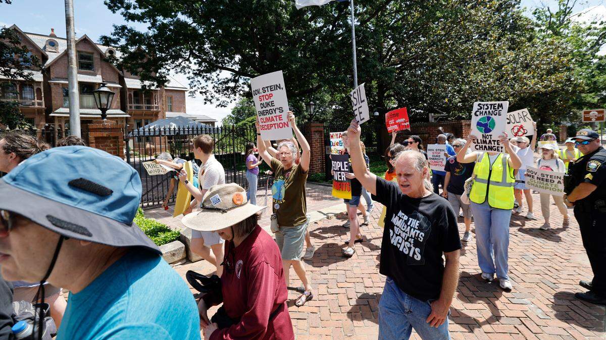 Protesters walk around the N.C. Executive Mansion during a rally and march organized by NC WARN in Raleigh Saturday. About 85 people gathered to pressure Gov. Josh Stein to speak out against Duke Energy and push the state’s monopoly utility to embrace renewable energy.