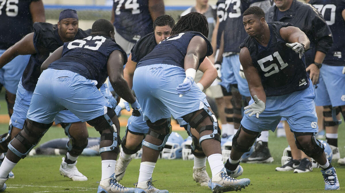 North Carolina offensive tackle William Sweet (51) works out with teammates in light rain during the Tar Heels’ first practice of football camp on Friday, August 3, 2018 at Kenan Stadium in Chapel Hill, N.C.