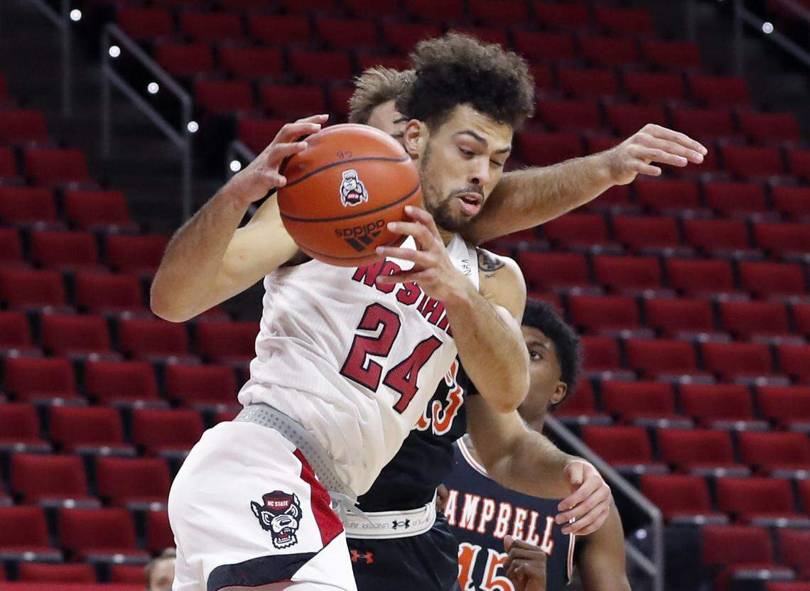 N.C. State’s Devon Daniels (24) pulls in the rebound from Campbell’s Billy Phenicie (13) during the first half of N.C. State’s game against Campbell at PNC Arena in Raleigh, N.C., Saturday, Dec. 19, 2020.