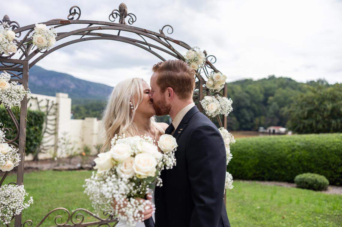 Sereyna, left, and her husband Gavin Walker share a kiss after their wedding ceremony at The 1927 Lake Lure Inn and Spa in Lake Lure, N.C. on Saturday, September 28, 2024.