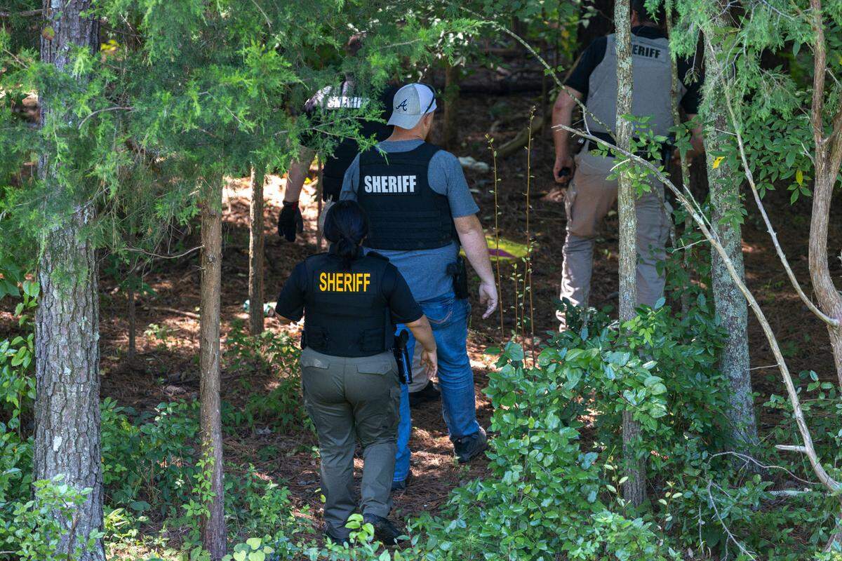 Alamance County Sheriff’s Deputies enter a wooded area to search for escaped inmate Ramone Alston on Wednesday morning August 14, 2024 in Hillsborough, N.C. Alston, who was serving a life sentence for second degree murder, escaped on Tuesday morning at UNC Hospitals in Hillsborough as he was being transported from Bertie Correctional Institute to Hillsborough.