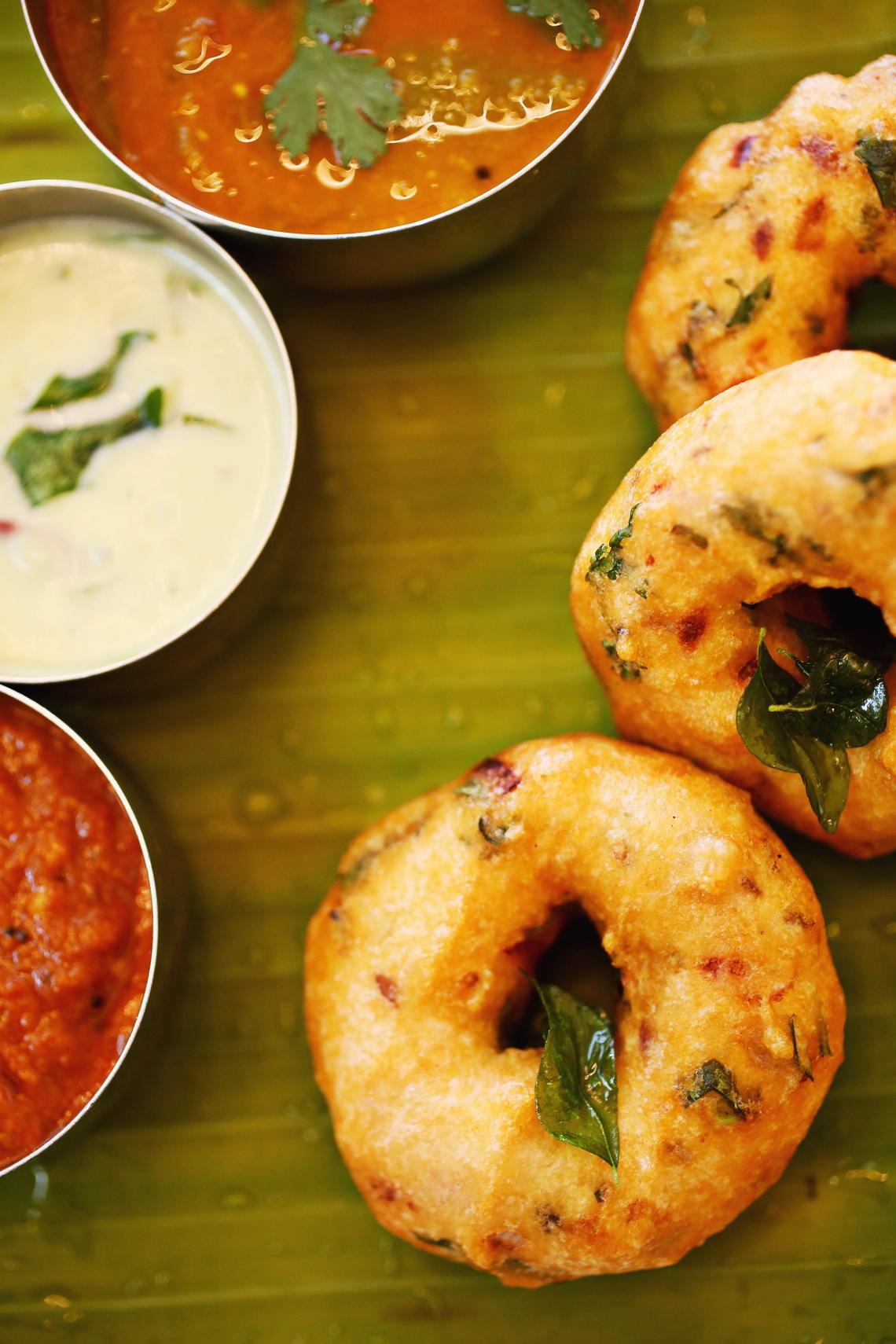 Persis Indian Grill’s Media Vada is made up of donut-shaped, cilantro- and chile-flecked fritters served on a banana leaf with the traditional accompaniments of sambar, coconut chutney and tomato chutney.