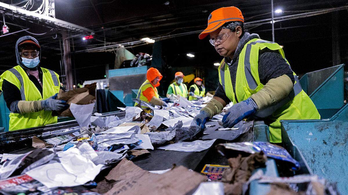 Martina Garcia, right, works on the paper quality control line at a Sonoco materials recovery facility on Tuesday, Jan. 17, 2023, in Raleigh, N.C. The recycling plant receives material from all of Raleigh’s residential blue bins, along with recycling from Durham, Fuquay-Varina and some smaller community drop-off centers.