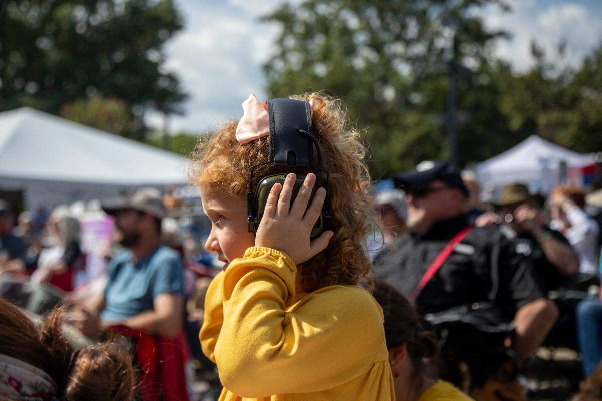 Emery Warner, 3, wears hearing protection as the Chatham Rabbits perform outside the Duke Energy Center for the Performing Arts during the IBMA World of Bluegrass festival in downtown Raleigh Friday, Oct. 1, 2021.