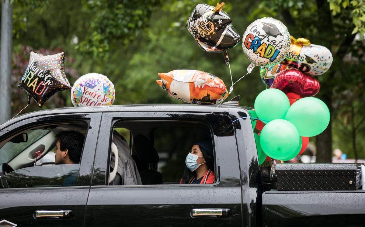 Edilia Epitacio arrives to the socially distanced graduation ceremony at Southeast Raleigh High School in a truck covered in balloons on Wednesday, May 27, 2020.