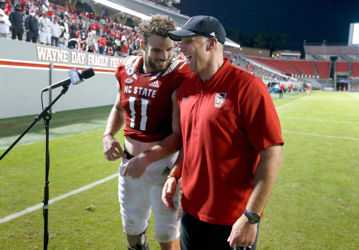 N.C. State head coach Dave Doeren laughs with Payton Wilson (11) after N.C. State’s 31-20 victory over Duke at Carter-Finley Stadium in Raleigh, N.C., Saturday, Oct. 17, 2020.