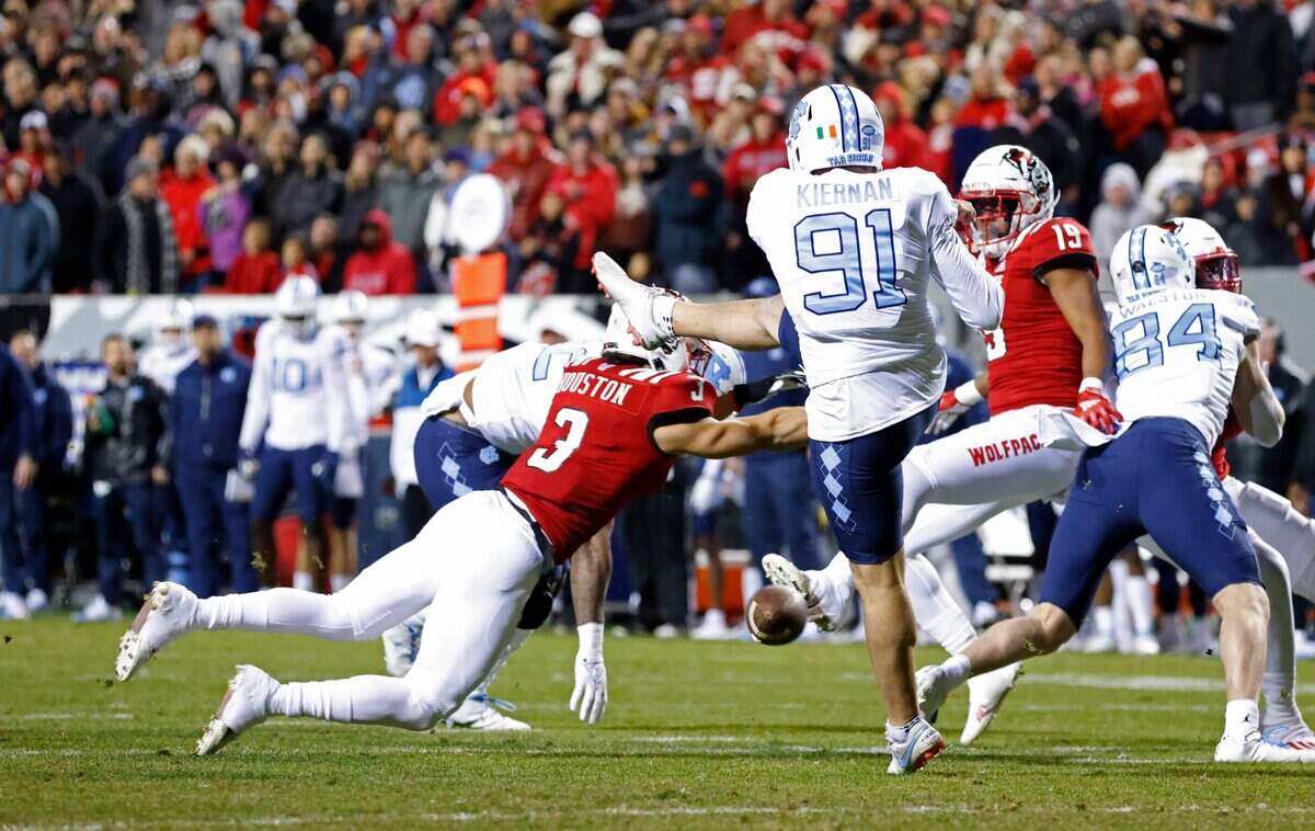 N.C. States Jordan Houston (3) blocks the punt by North Carolinas Ben Kiernan (91) during the first half of N.C. States game against UNC at Carter-Finley Stadium in Raleigh, N.C., Friday, November 26, 2021.