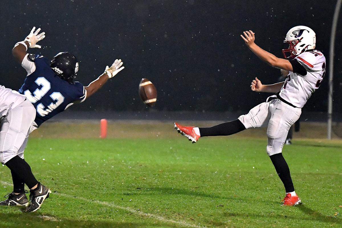 Millbrook defensive lineman Markez Wilbert (33) stretches to block the punt by Jordan punter Asher Holland (31) during the first half. The Millbrook Wildcats and the Jordan Falcons met in the third round of the NCHSAA 8A football playoffs in Raleigh, N.C. on November 21, 2025. 