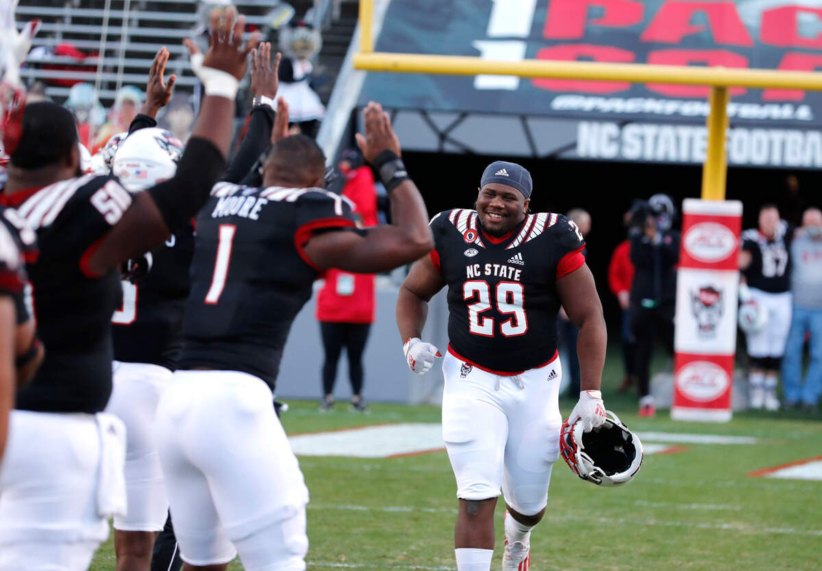 Players bow down to N.C. State defensive tackle Alim McNeill (29) as he runs out after being acknowledged on senior day before N.C. State’s game against Georgia Tech at Carter-Finley Stadium in Raleigh, N.C., Saturday, Dec. 5, 2020.