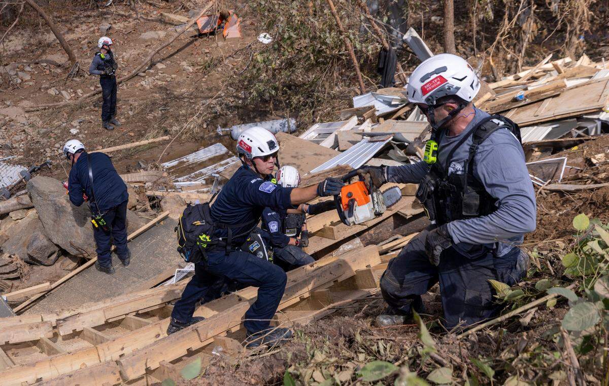 A FEMA search and rescue team from Maryland search for human remains in debris from a structure in Swannanoa on Sunday, Oct. 6, 2024 after Tropical Storm Helene flooded the Swannanoa River. North Carolina officials have confirmed 76 deaths from Tropical Storm Helene.