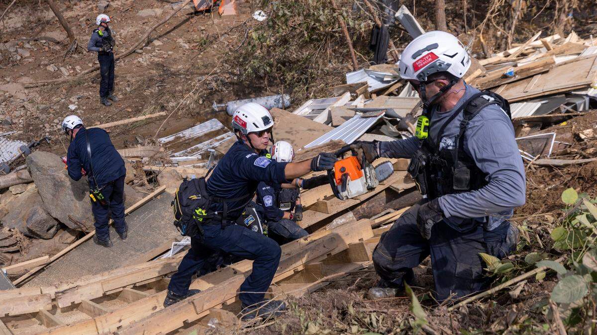 A FEMA search and rescue team from Maryland search for human remains in debris from a structure in Swannanoa on Sunday, Oct. 6, 2024 after Tropical Storm Helene flooded the Swannanoa River. North Carolina officials have confirmed 76 deaths from Tropical Storm Helene.