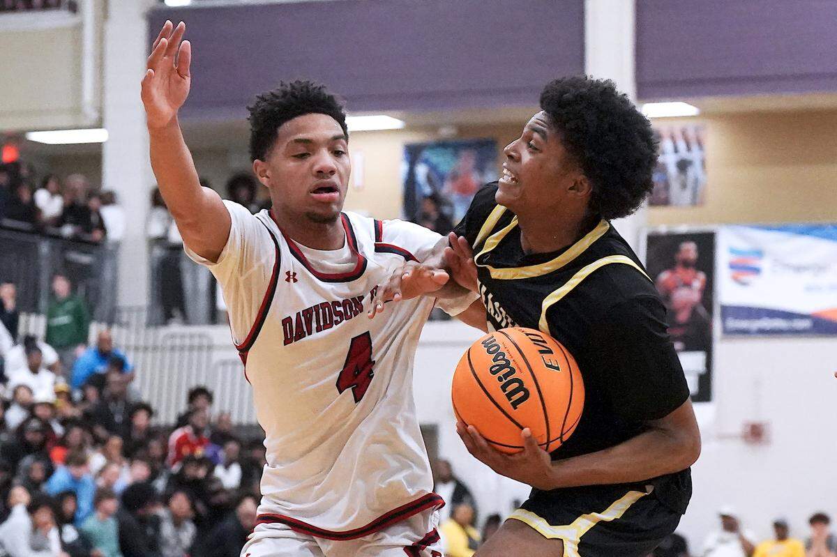 Southeastern Prep's Jayden Wilkins (2) drives to the basket and is fouled by Davidson Day's Omari Whiteside (4) during the first half. The Davidson Day Patriots and the Southeastern Prep Academy National Falcons met in the John Wall Holiday Tournament in Raleigh, N.C. on December 27, 2025.
