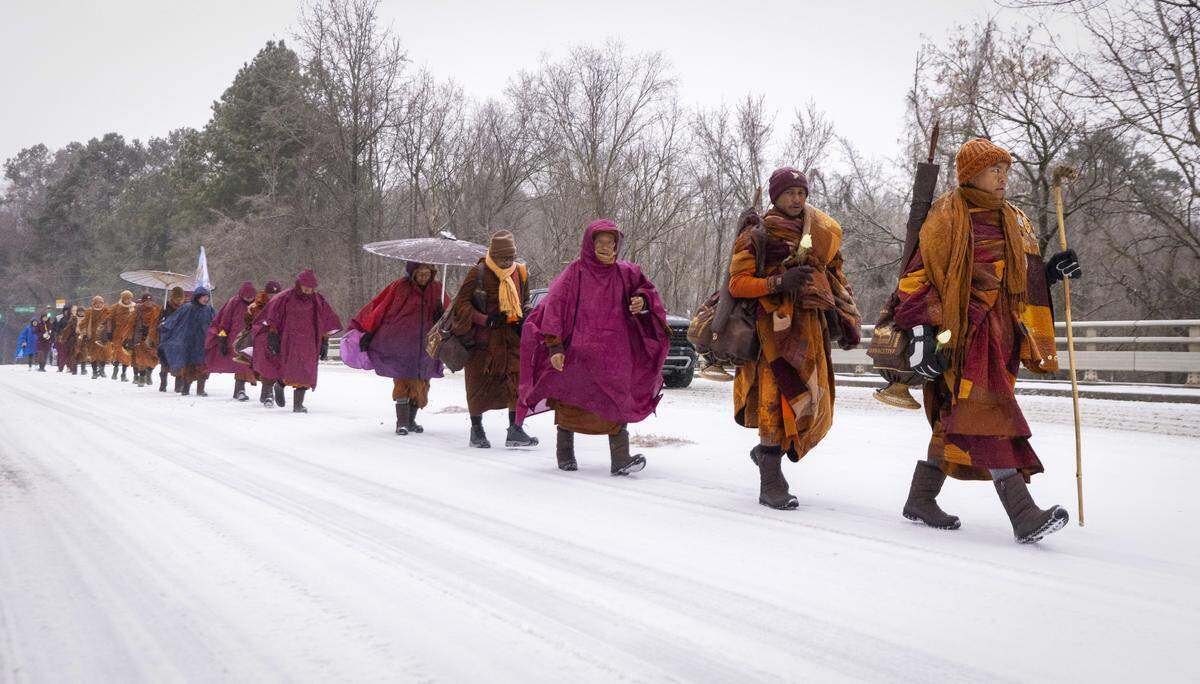 A procession of Buddhist monks walks along snow-covered Raleigh Boulevard in Raleigh on Sunday morning, Jan. 25, 2026. The monks are making a 2,300-mile pilgrimage from Texas to Washington, D.C., as part of the Walk for Peace, an effort to promote peace, compassion and national unity.