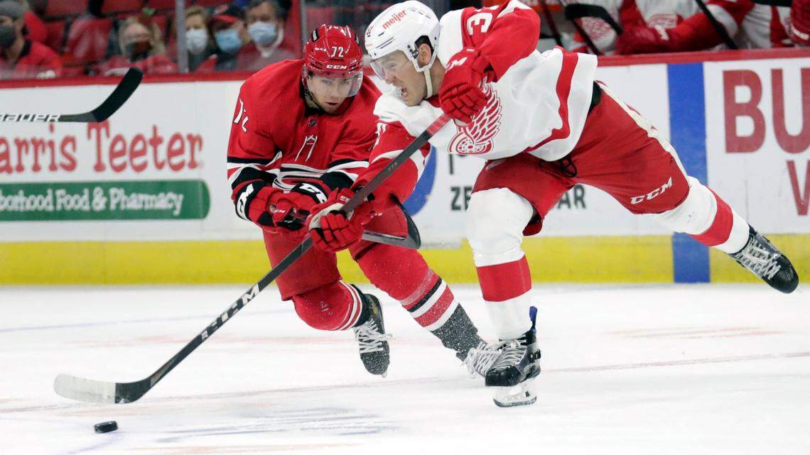 Carolina Hurricanes center Jack Drury (72) chases Detroit Red Wings center Carter Rowney (37) who moves the puck during the first period of an NHL hockey game Thursday, Dec. 16, 2021, in Raleigh, N.C. (AP Photo/Chris Seward)