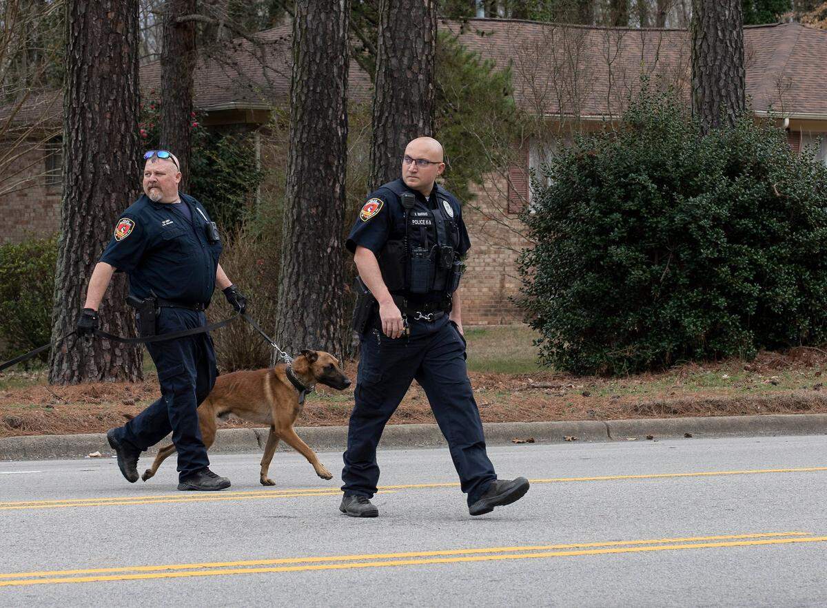 Law enforcement officers walk across NC-55 on Thursday, Feb. 9, 2023, in Durham, N.C.
