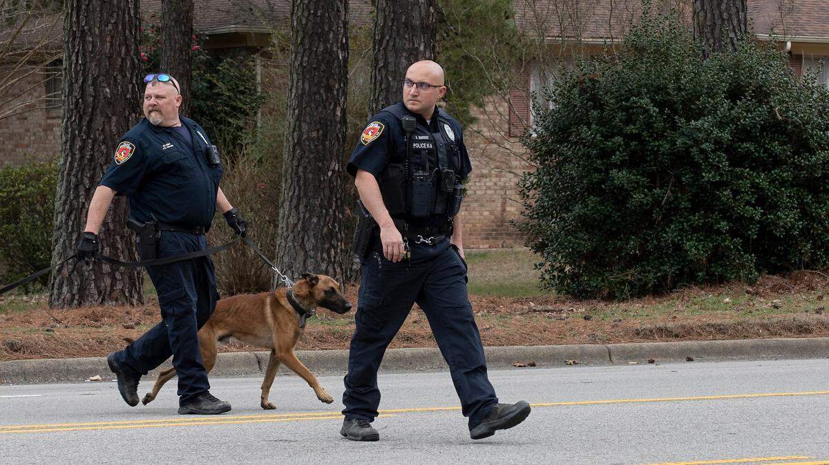 Law enforcement officers walk across NC-55 on Thursday, Feb. 9, 2023, in Durham, N.C.