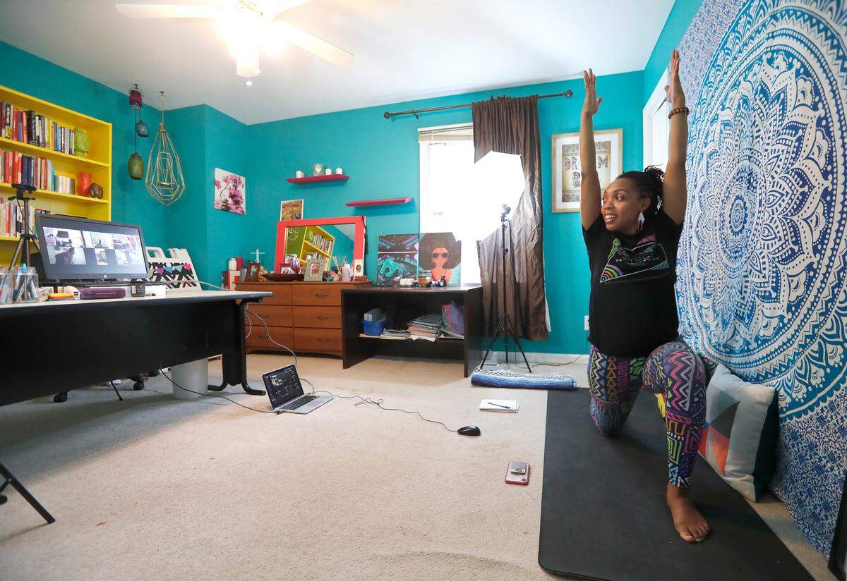 Patrice Graham, owner of Colors of Yoga Raleigh, leads a virtual yoga class using Zoom in her home Wednesday, March 25, 2020. Zoom allows Graham to interact and connect with her students.