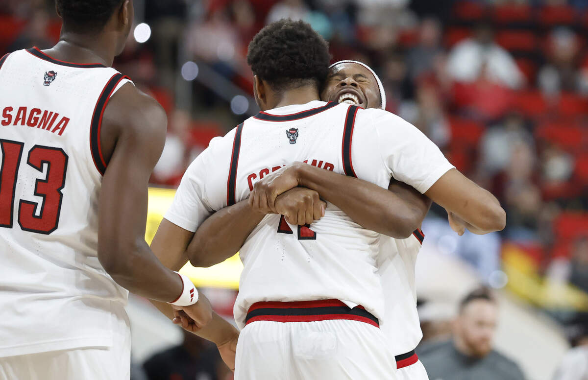 N.C. State's Tre Holloman (5) hugs Quadir Copeland (11) in the first half of N.C. State’s game against UNC Asheville at the Lenovo Center in Raleigh, N.C., Saturday, Dec. 6, 2025.