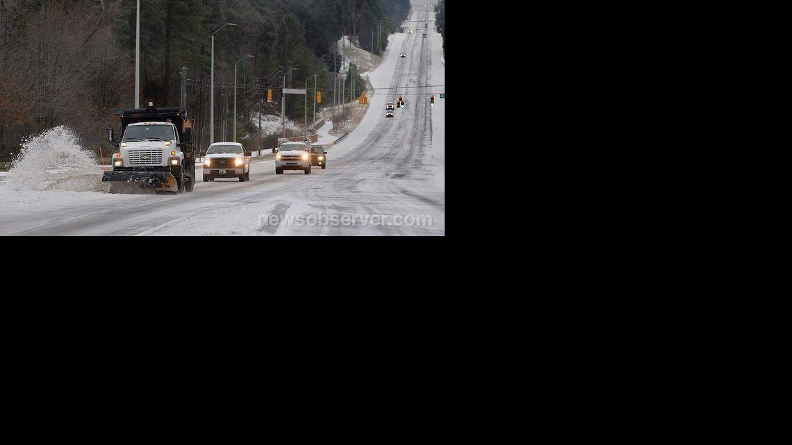 A Town of Cary snowplow scapes ice and snow from the northbound lanes of Highway 55 near the intersection with High House Road in Cary, NC Tuesday morning, Feb. 17, 2015.

