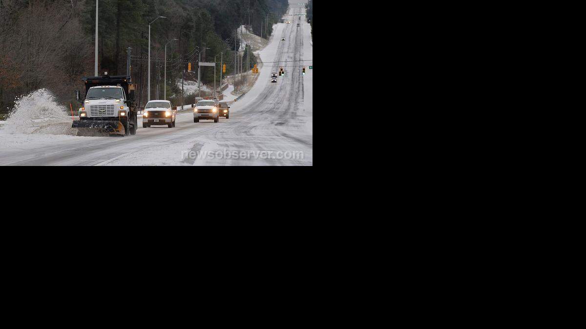 A Town of Cary snowplow scapes ice and snow from the northbound lanes of Highway 55 near the intersection with High House Road in Cary, NC Tuesday morning, Feb. 17, 2015.
