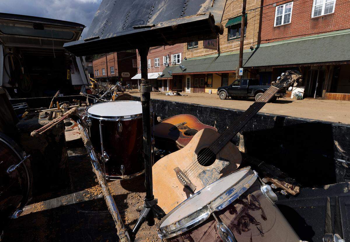 Mud-splattered instruments sat in the back of a truck as volunteers cleared debris from Majestic Music in downtown Spruce Pine days after Helene struck.