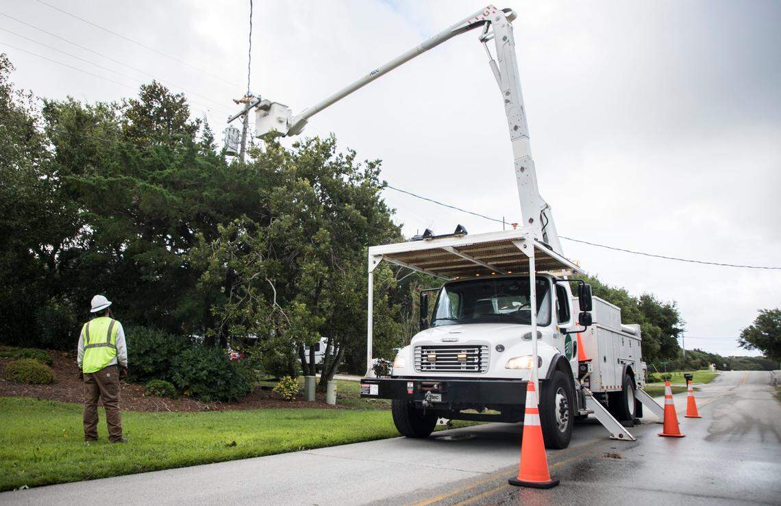 Contractors with the Carteret-Craven Electric Cooperative work on bringing power back to homes in Pine Knoll Shores, N.C. on Tuesday morning, Aug. 4, 2020 after Hurricane Isaias, which later became a tropical storm, passed through the area causing power outages.