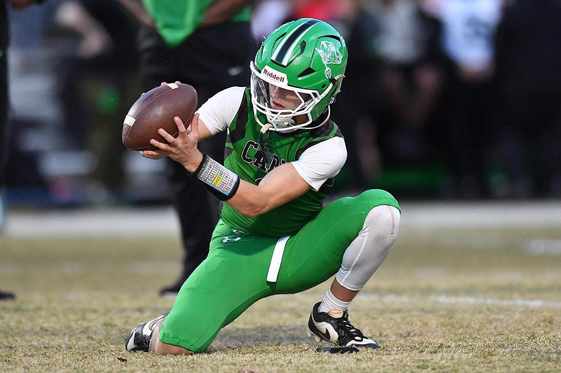 Cary quarterback Nick Grena (3) prepares to set the ball for the kicker during pregame drills before taking on Middle Creek. The Cary Imps and the Middle Creek Mustangs met in a conference football game in Cary, N.C. on October 24, 2025