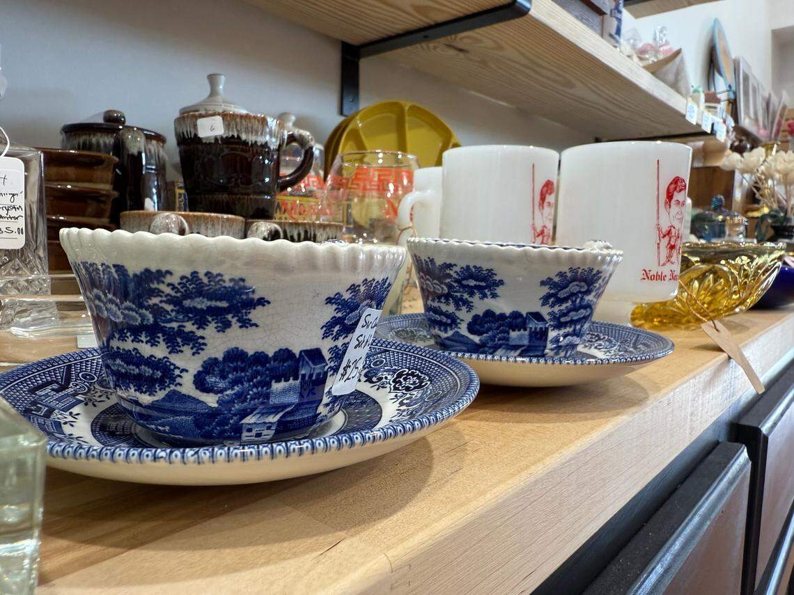 A pair of antique cups and saucers sit among the vintage kitchenware at The Burrow.