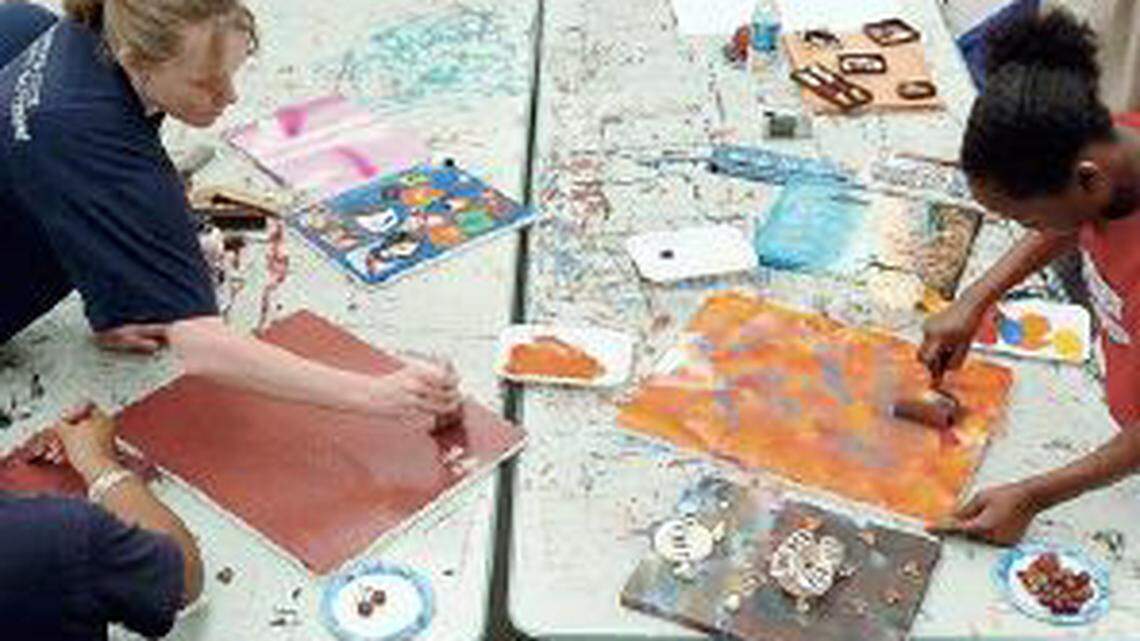 Blue Ribbon mentor Stephanie Kien, left, and middle school student Rebecca Ray, right, work to open windows into their own lives through artwork in a UNC-Chapel Hill art studio in this file photo.