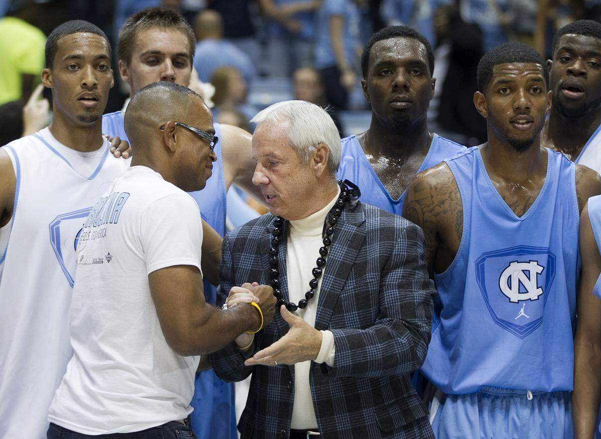 UNC coach Roy Williams shakes hands with ESPN's Stuart Scott following the annual "Late Night with Roy Williams" in October 2012 at the Smith Center in Chapel Hill, N.C.