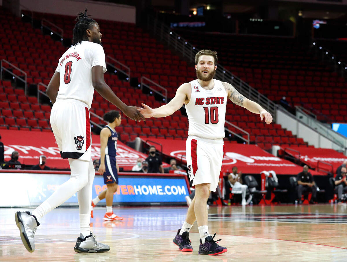 N.C. State’s Braxton Beverly (10) congratulates D.J. Funderburk (0) during the second half of Virginia’s 64-57 victory over N.C. State at PNC Arena in Raleigh, N.C., Wednesday, February 3, 2021.