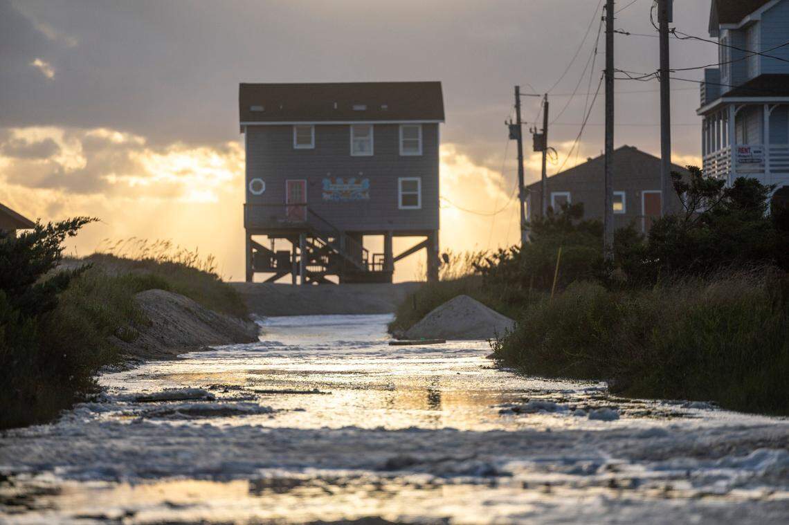 Ocean overwash settles in the street behind beach homes in Rodanthe Friday, Sept, 15, 2023 as Hurricane Lee churns in the Atlantic hundreds of miles offshore.