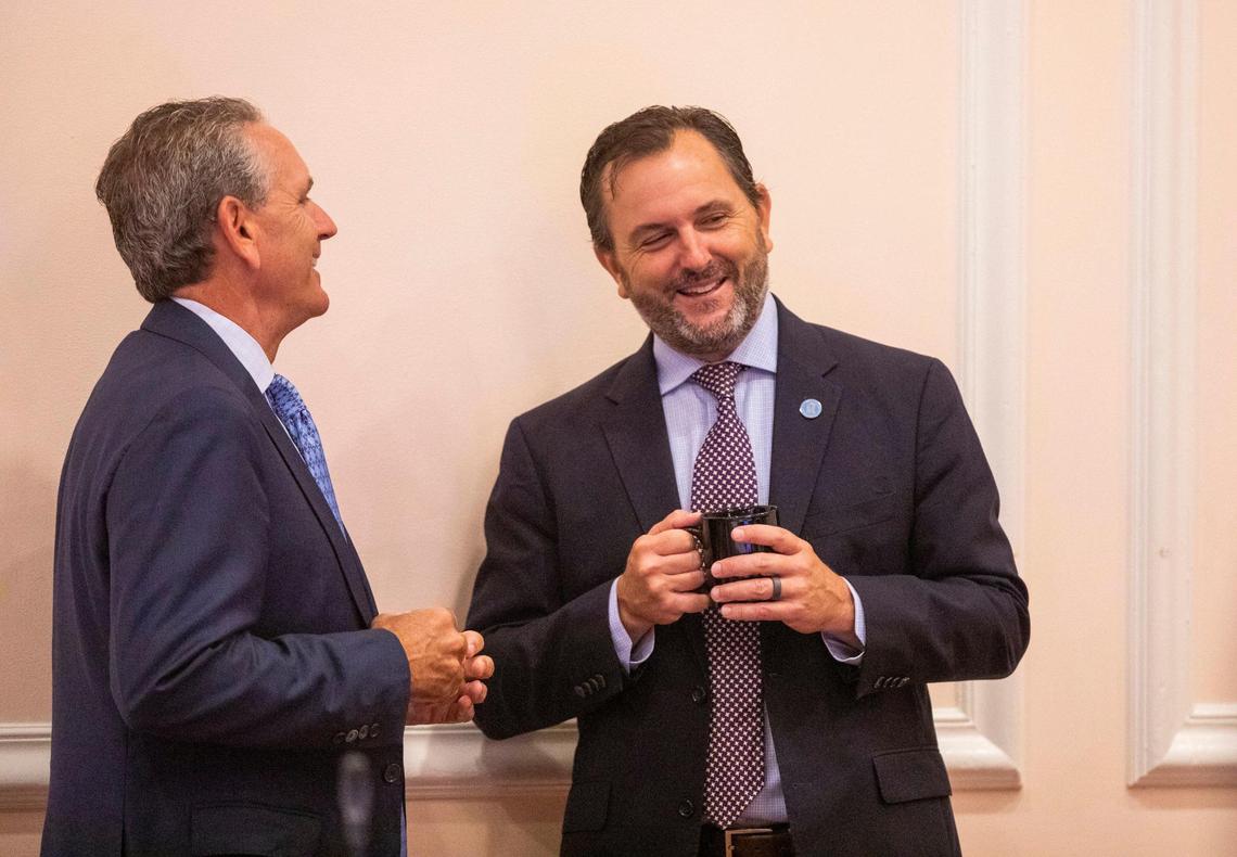 Rob Bryan, right, socializes before the start of his first meeting as a member of the UNC Board of Trustees, at the Carolina Inn, on Thursday, July 15, 2021, in Chapel Hill, N.C.