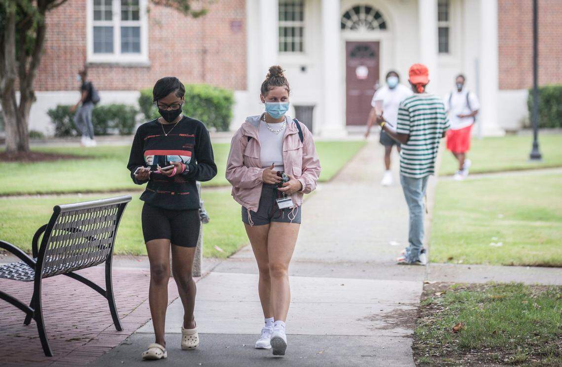Taylor Pearson, left, and Molly Wood, middle, both first year students at N.C. Central University in Durham, N.C., walk towards Pearson Cafeteria for lunch on the first day of classes, Monday, Aug. 24, 2020.
