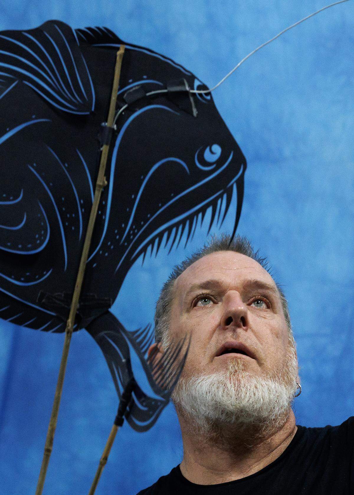 Donovan Zimmerman, co-founder and director of Paperhand Puppet Intervention, tests a fish shadow puppet while working at the company’s new studio on Saturday, July 26, 2025, in Graham, N.C. 