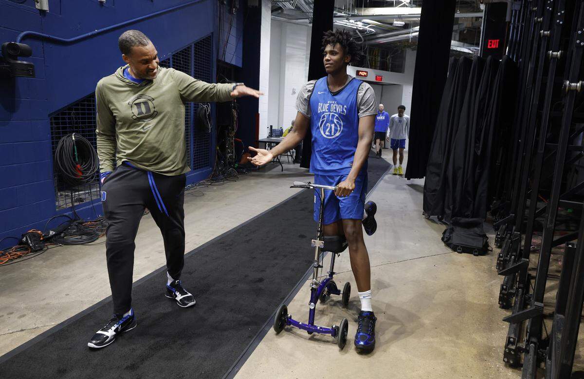 Associate head coach Chris Carrawell shakes hands with Patrick Ngongba II as they head out to practice before the Blue Devils’ practice at Capital One Arena in Washington, D.C., Thursday, March 26, 2026. The Blue Devils face St. John’s in the Sweet 16 of the NCAA Men’s Basketball East Regional Friday.