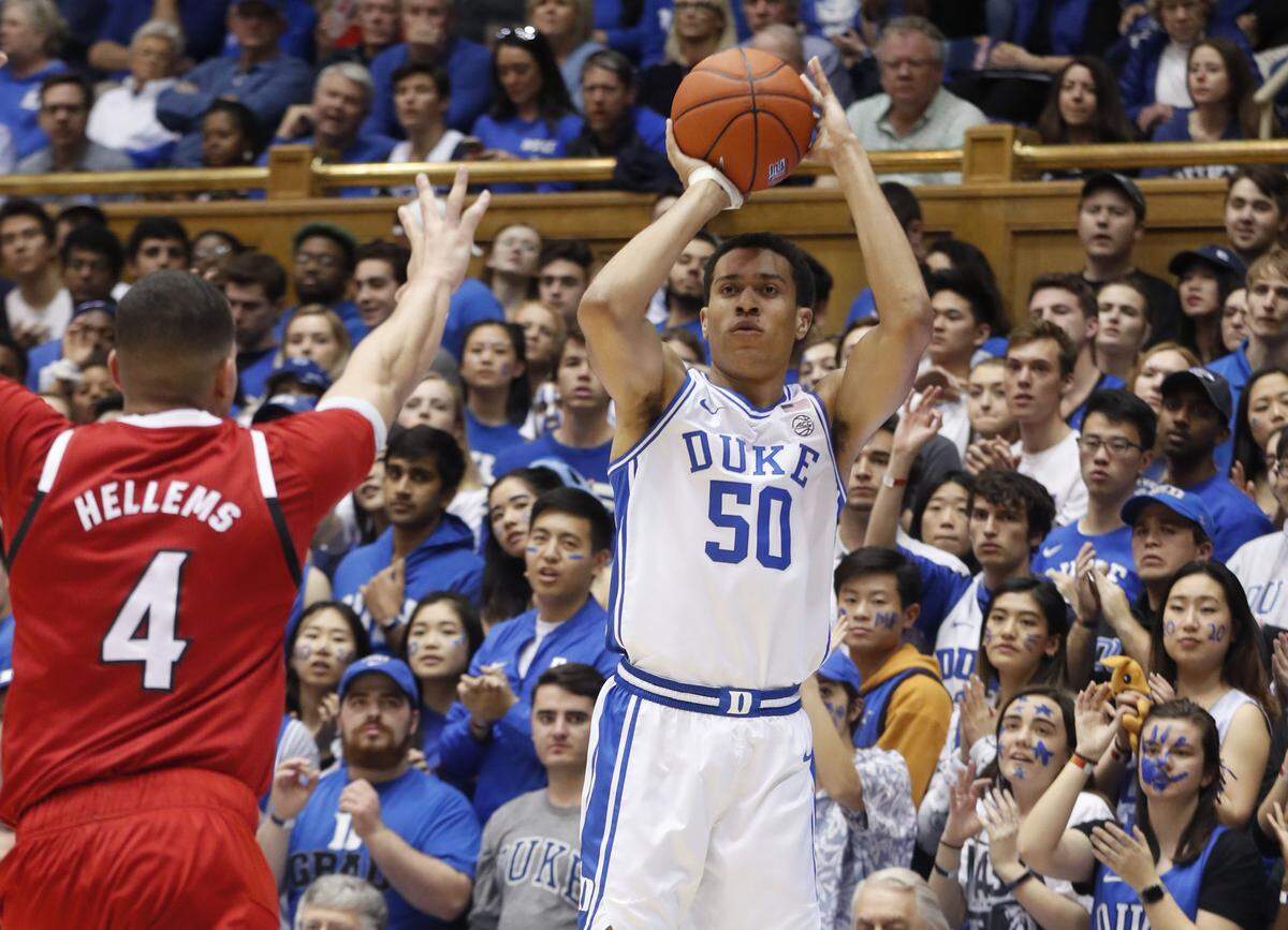 Duke’s Justin Robinson (50) hits a three-pointer as N.C. State’s Jericole Hellems (4) ties to defend during the first half of the N.C. State Wolfpack’s game against the Duke Blue Devils at Cameron Indoor Stadium in Durham, N.C., Monday, March 2, 2020.