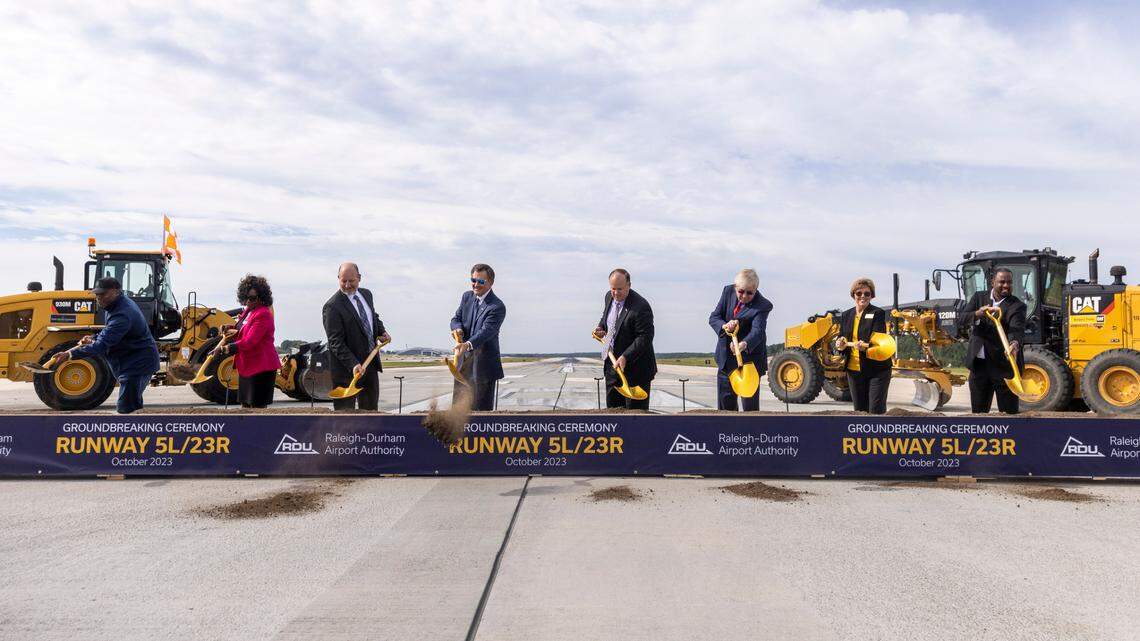 Politicians and business and community leaders take part in a groundbreaking ceremony on runway 5L/23R at RDU International Airport in Morrisville, Wednesday, Oct. 11, 2023. A new, longer 5L/23R, will be built northwest and parallel to the existing runway near Terminal 2.