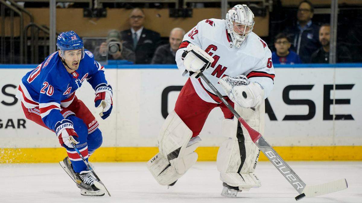 Carolina Hurricanes goaltender Pyotr Kochetkov (52) clears the puck away from New York Rangers left wing Chris Kreider (20) during the first period of an NHL hockey game, Tuesday, April 26, 2022, in New York. (AP Photo/John Minchillo)
