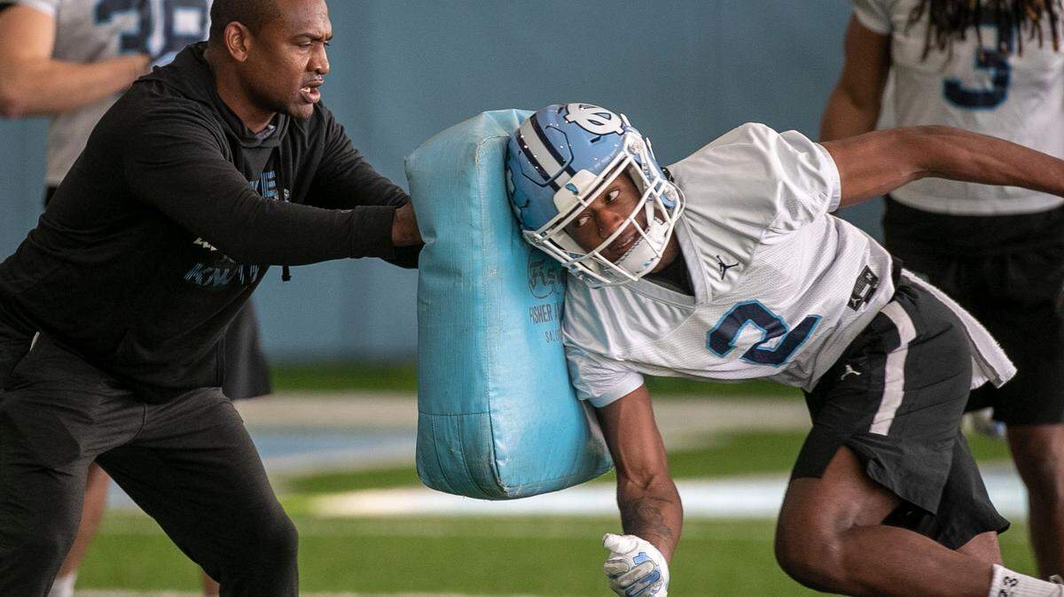 North Carolina cornerbacks coach Dre Bly works with defensive back Don Chapman (2) during the opening day of the Tar Heels’ spring football practice on Tuesday, March 1, 2022 in Chapel Hill, N.C.