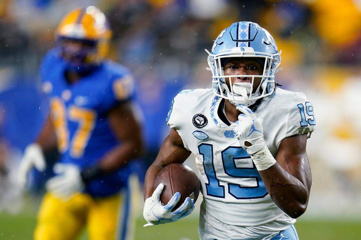 North Carolina running back Ty Chandler (19) makes a long run as Pittsburgh defensive lineman Habakkuk Baldonado (87) pursues during the second half of an NCAA college football game Thursday, Nov. 11, 2021, in Pittsburgh. Pittsburgh won 30-23 in overtime. (AP Photo/Keith Srakocic)