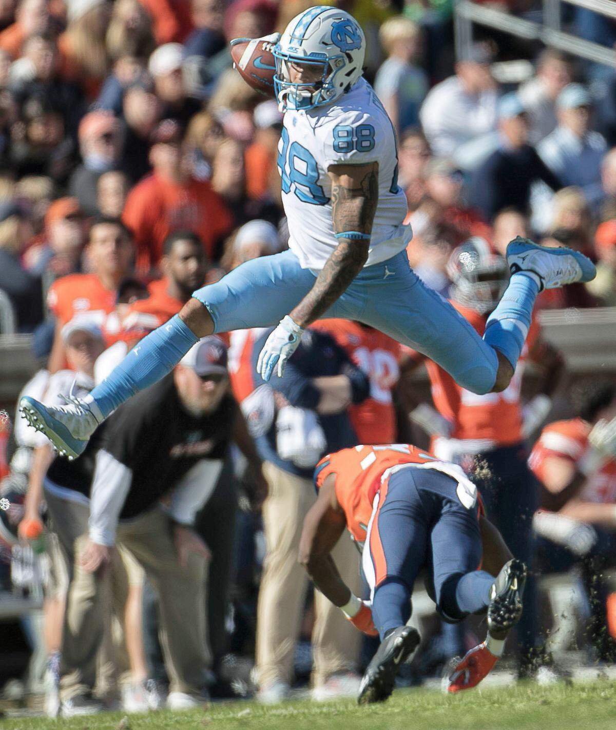 North Carolina’s Beau Corrales (88) hurdles over Virginia’s Darrius Bratton (32) after a 28-yard pass completion from quarterback Nathan Elliott in the second quarter on Saturday, October 27, 2018 at Scott Stadium in Charlottesville, Va.