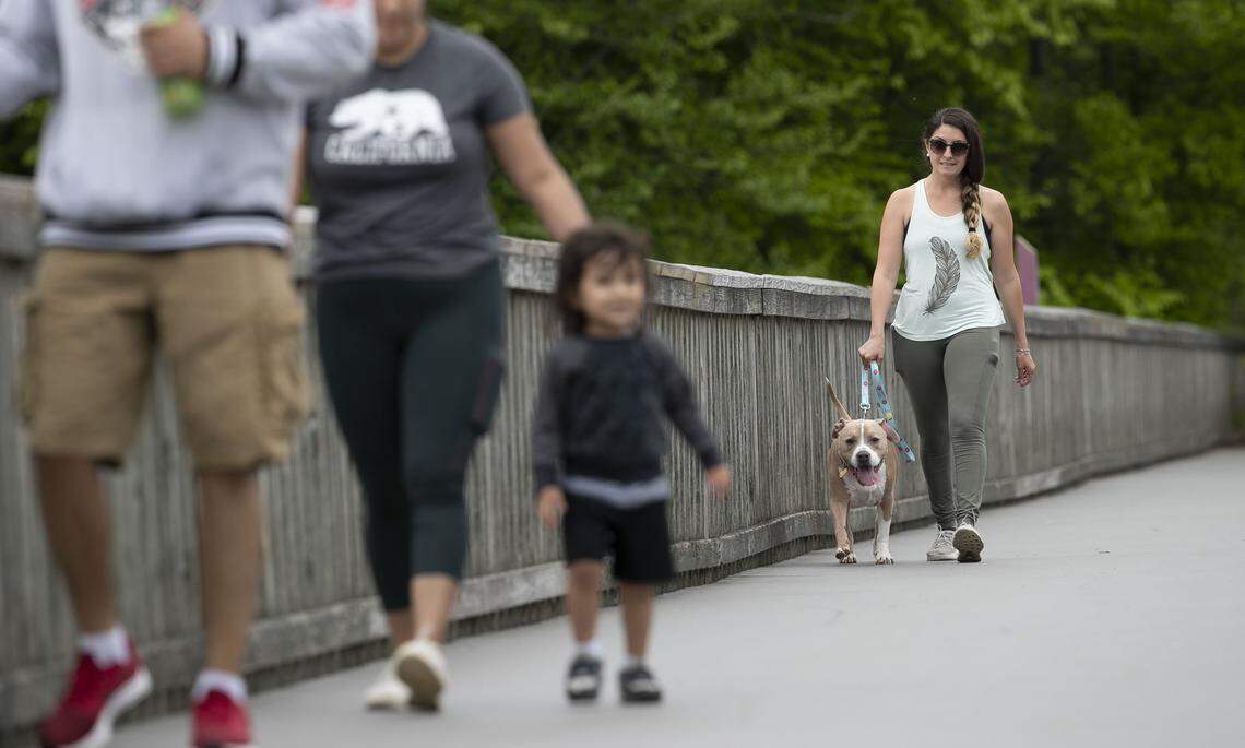 Francesca Como and her dog Brody take a walk around Lake Johnson on Sunday, April 26, 2020 in Raleigh, N.C. All of the boating, concessions and bathroom facilities are closed due to the spread of the COVID-19 virus, The popular park offers more than five miles of trails around the lake which remain open during the pandemic.