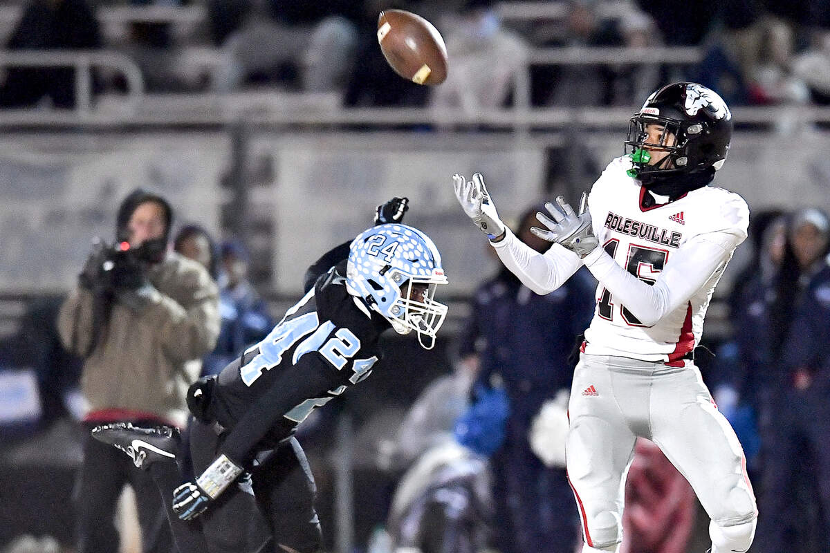 Rolesville wide receiver Anthony Roberts (15) preps to catch the pass against Cleveland defensive back Theron Batiste (24) and runs for the touchdown during the first half. The Rolesville Rams and the Cleveland Rams met in the fourth round of the NCHSAA 4A football playoffs in Clayton, N.C. on December 6, 2024.