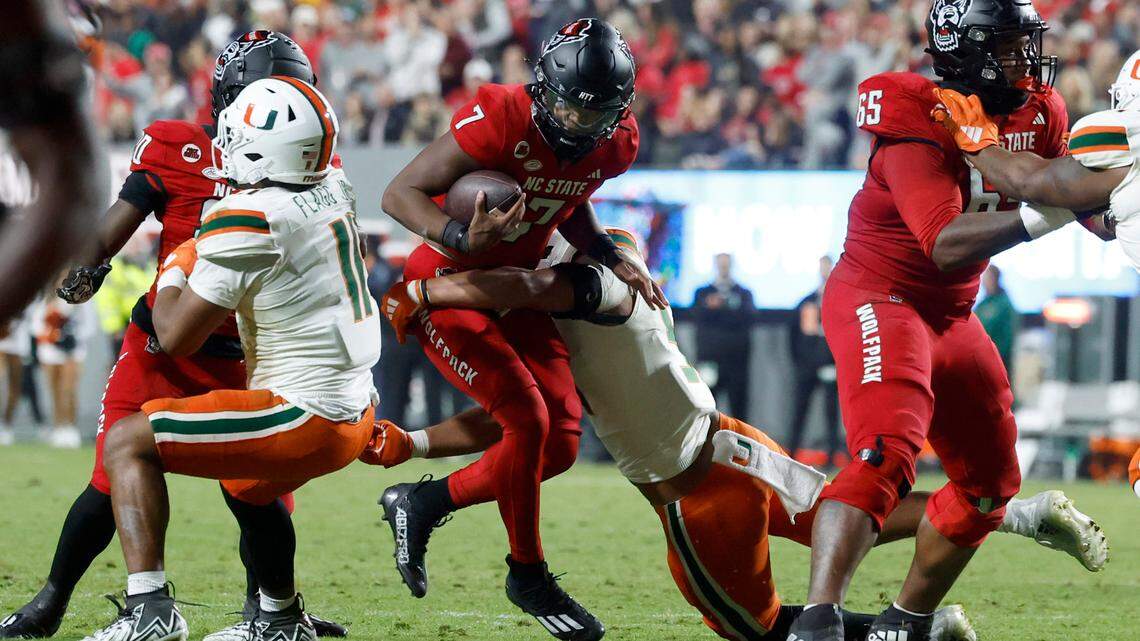 N.C. State quarterback MJ Morris (7) is sacked by Miami linebacker Francisco Mauigoa (51) during the first half of N.C. State’s game against Miami at Carter-Finley Stadium in Raleigh, N.C., Saturday, Nov. 4, 2023.
