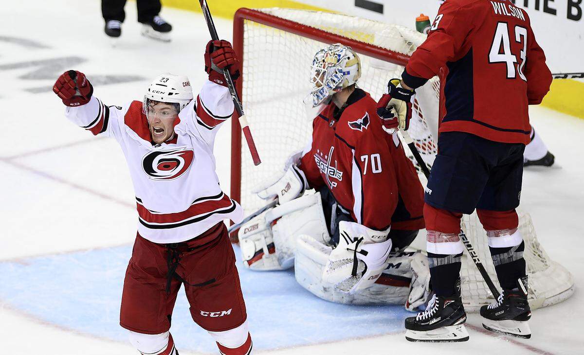 Carolina Hurricanes left wing Brock McGinn, left, celebrates his game-winning goal during double overtime of Game 7 of an NHL hockey first-round playoff series against Washington Capitals goaltender Braden Holtby (70) and right wing Tom Wilson (43), Wednesday, April 24, 2019, in Washington. The Hurricanes won 4-3 in double overtime.