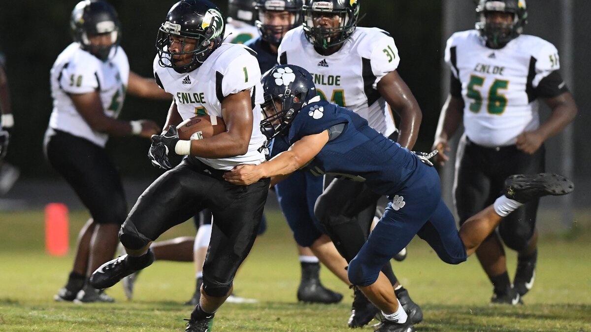 Hamilton Moore (1) of Enloe carries the ball against a tackle from Ethan Lentz, right, of Millbrook. The Enloe Eagles visited the Millbrook Wildcats in a high school football game on September 28, 2018.